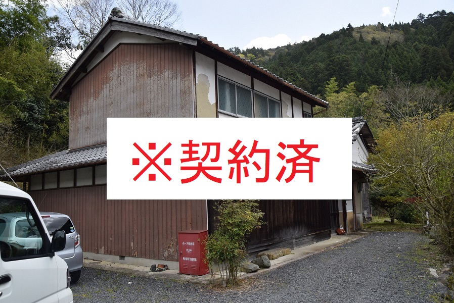 山の中にある木造の二階建ての家の写真