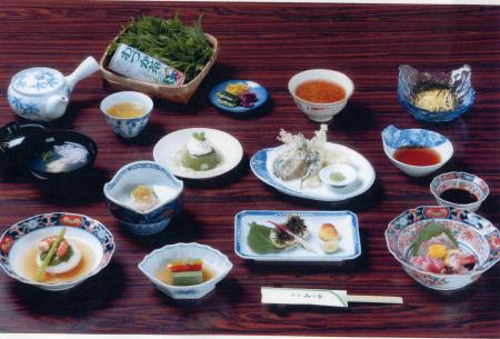 お吸い物、刺身、天ぷらなど様々な一品料理がテーブルの上に並べられてある茶懐石の写真