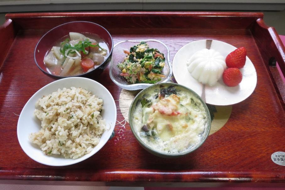 お盆の上にたぬき汁、小松菜サラダ、甘酒プリン、ごはん、花菜グラタンが並べて置かれてある写真