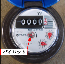 パイロットの部分を赤い矢印が指している丸い形の水道メーターの写真