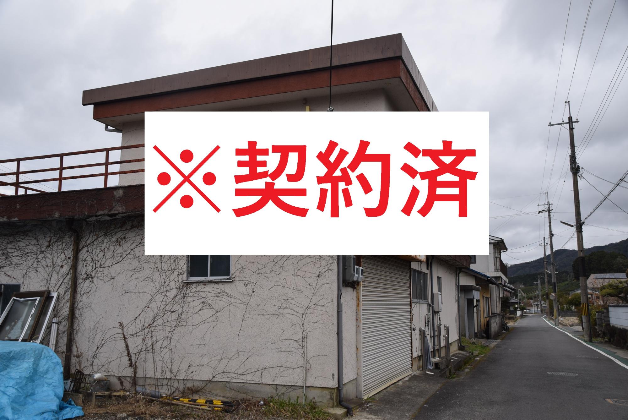 蔦が這った家の写真の中心に赤い文字で契約済みと記載されている写真