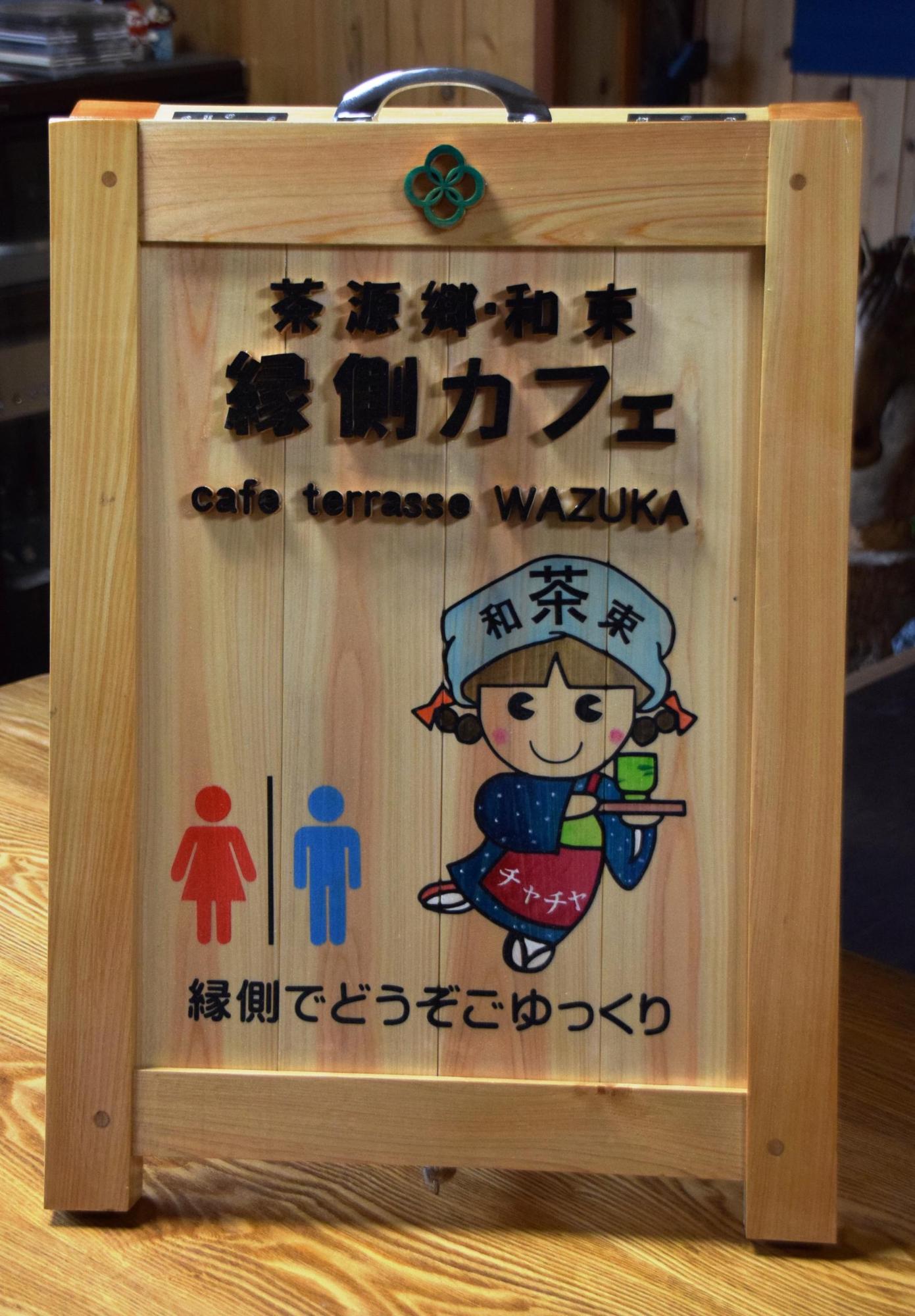 マスコットキャラクターやトイレのマークが記載された茶源郷和束・縁側カフェの看板の写真