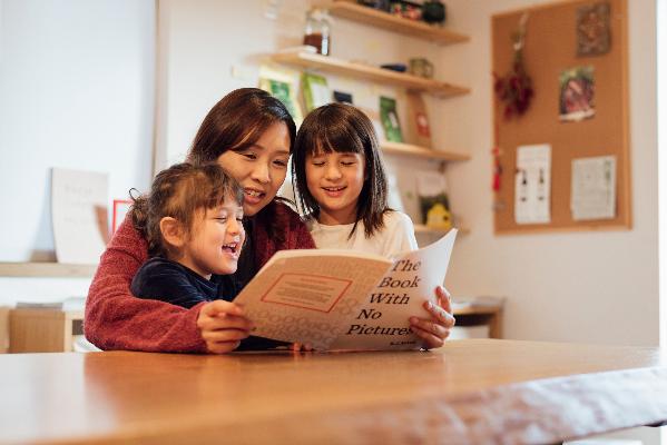 英語の本を読む女性と女生徒の写真